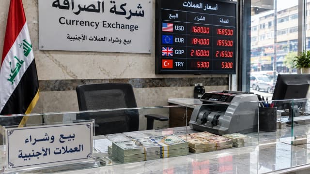 صورة مولدة تضهر مكتب صيرفة في العراق مع لوحة أسعار العملات.